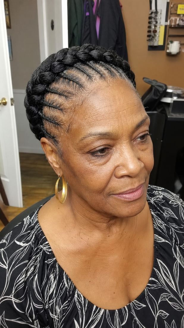 Black woman over 60 with cornrows shaped into a braided crown