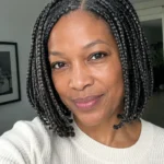 Older Black woman with chin-length box braids and a neat lightweight finish