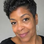 Older Black woman with a short tapered fro and soft side-framing shape