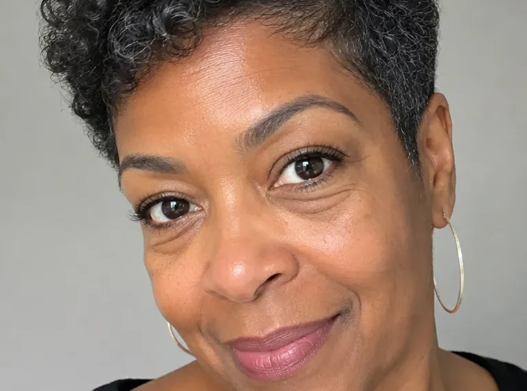 Older Black woman with a short tapered fro and soft side-framing shape