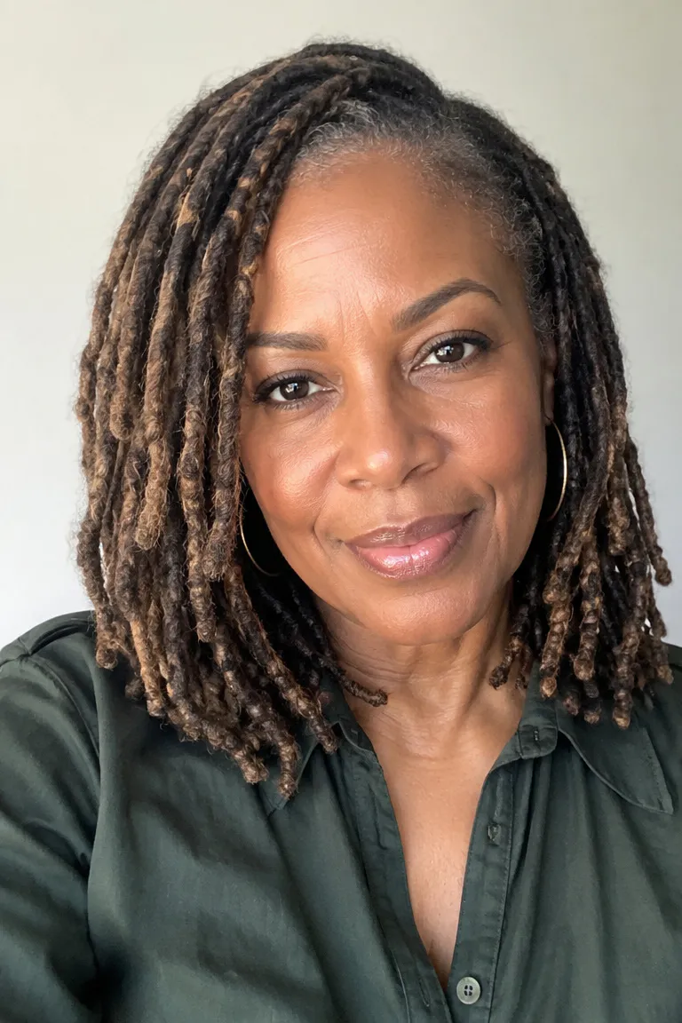 Black woman over 50 wearing shoulder-length faux locs with medium density