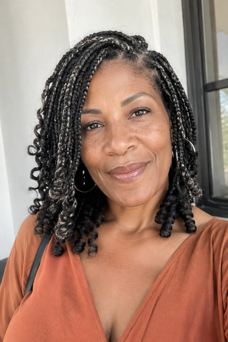 Older Black woman with short goddess braids that look full but light