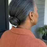 Low tucked bun with smooth sides and tucked ends