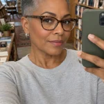 Rounded tapered fade with short gray curls, faded nape, and clipped sides